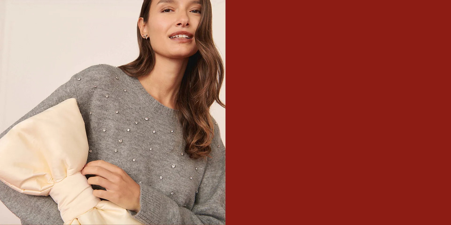 Pull gris élégant avec petits éléments décoratifs.