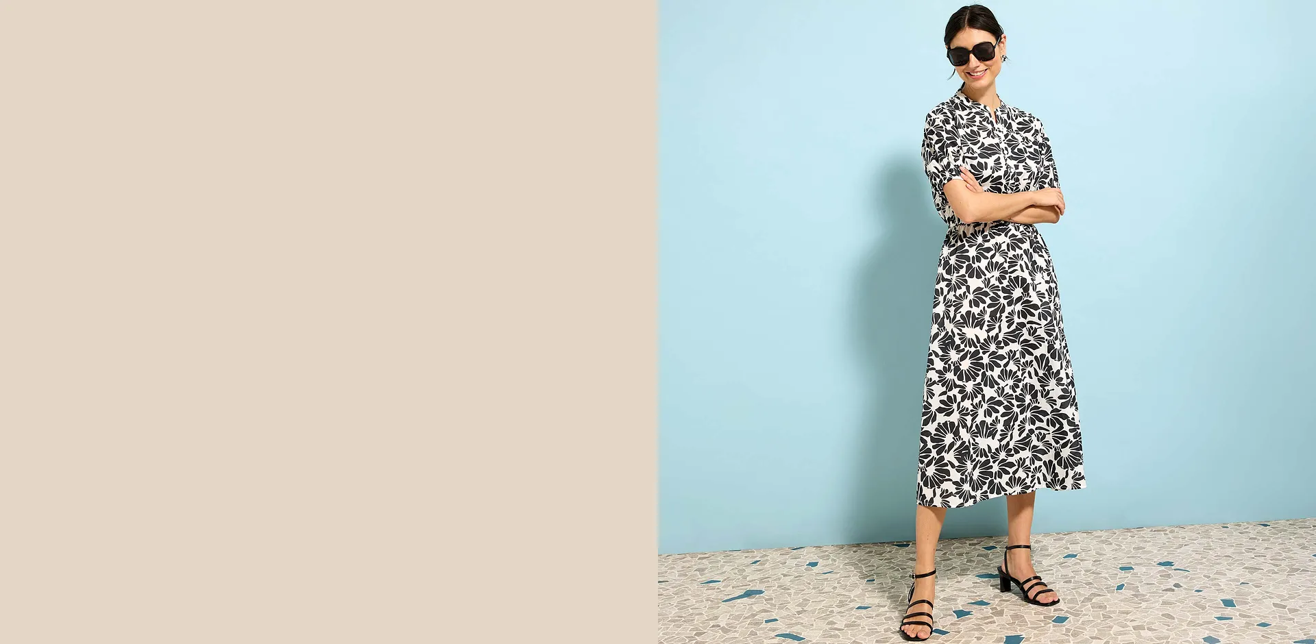 Robe midi estivale à motif floral en noir et blanc, lunettes de soleil et sandales pour un look élégant.