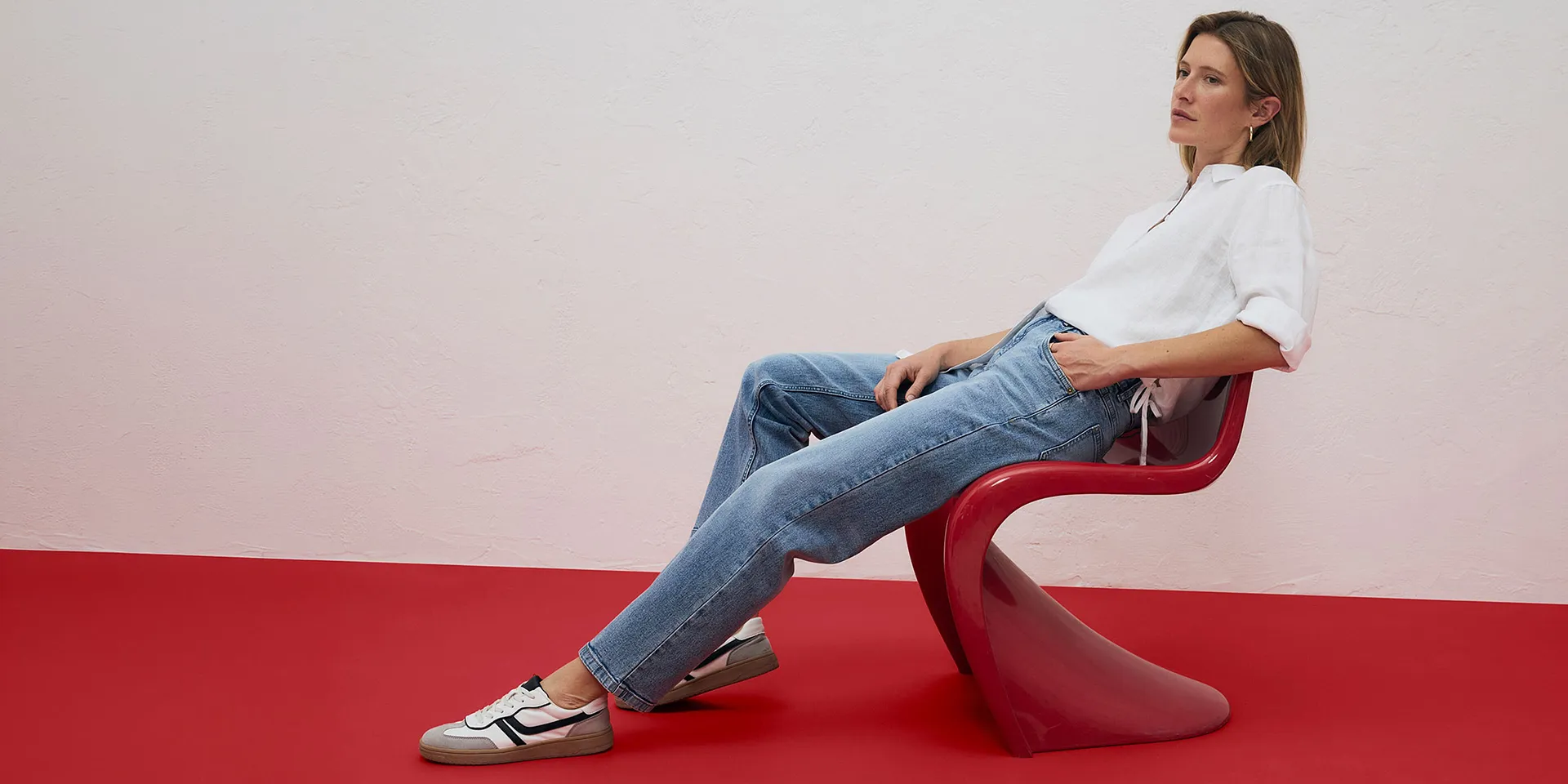 Chemisier blanc et jean bleu clair, complété d'une paire de sneakers.