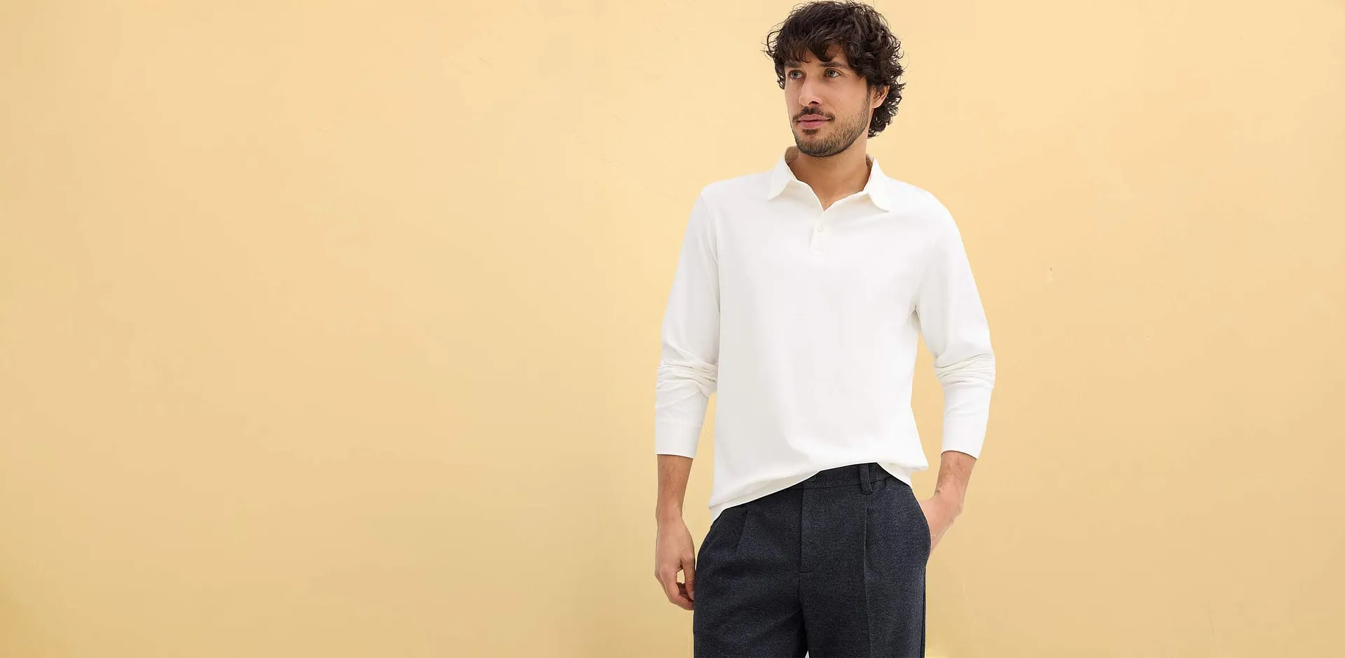 Polo manches longues blanc simple, associé à un pantalon foncé.