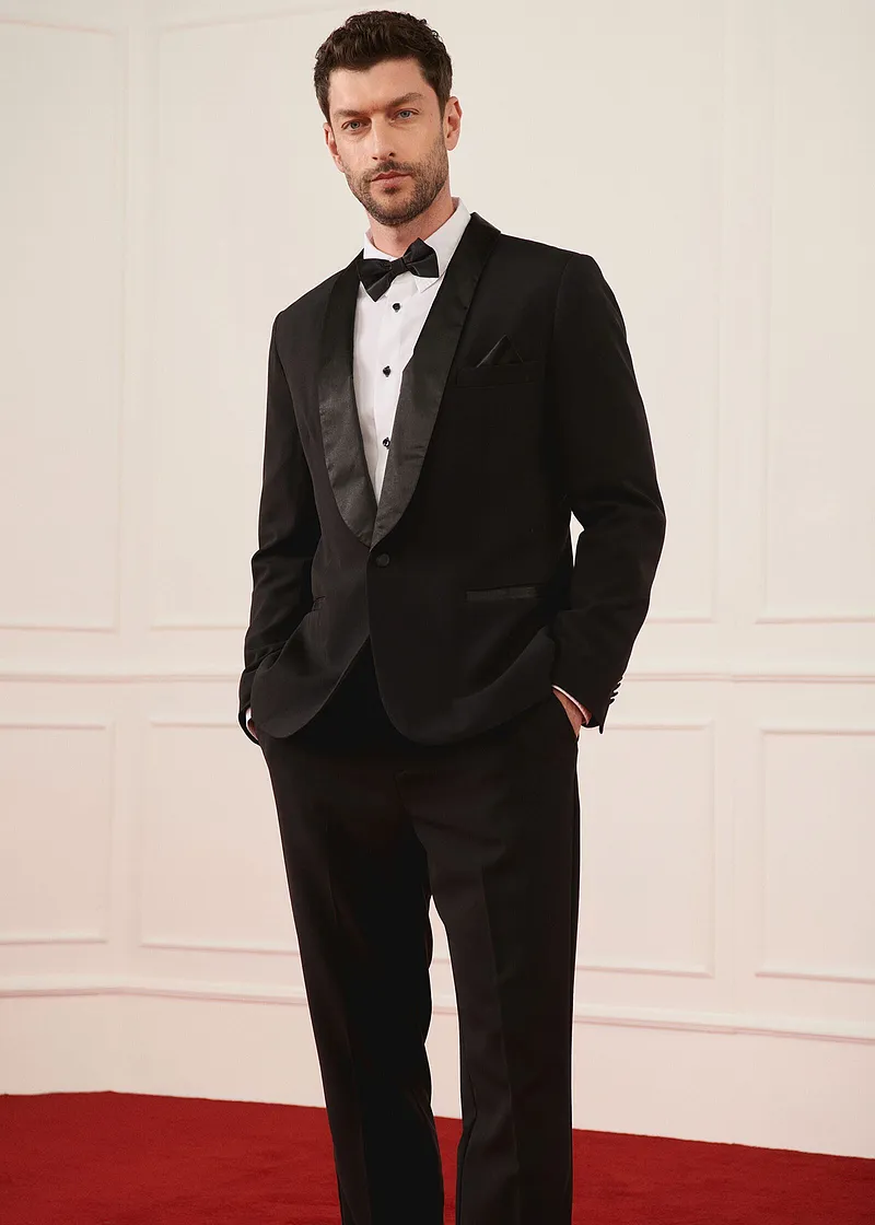 Smoking noir élégant avec nœud papillon et chemise blanche pour les grandes occasions.