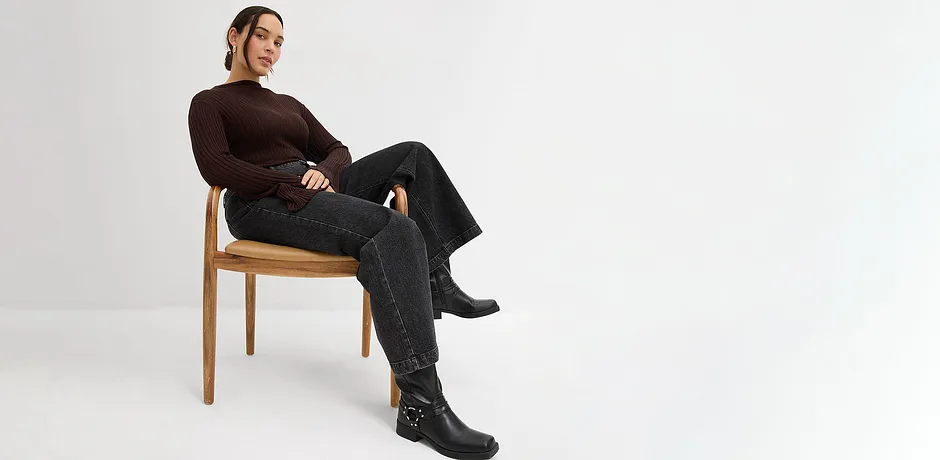 Haut à manches longues, jean noir et bottes.