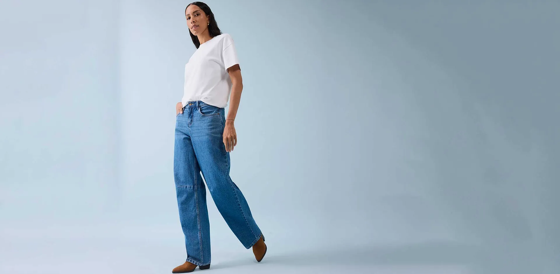 T-shirt blanc classique associé à un jean large et des chaussures marron.