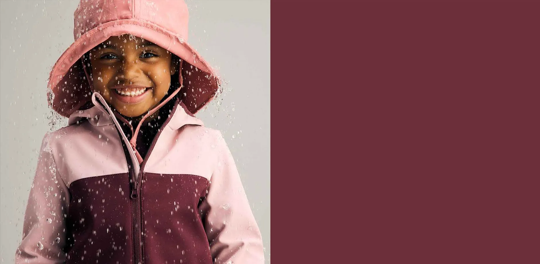 Veste imperméable en rose et bordeaux associée à un chapeau de pluie. La tenue parfaite par temps pluvieux.