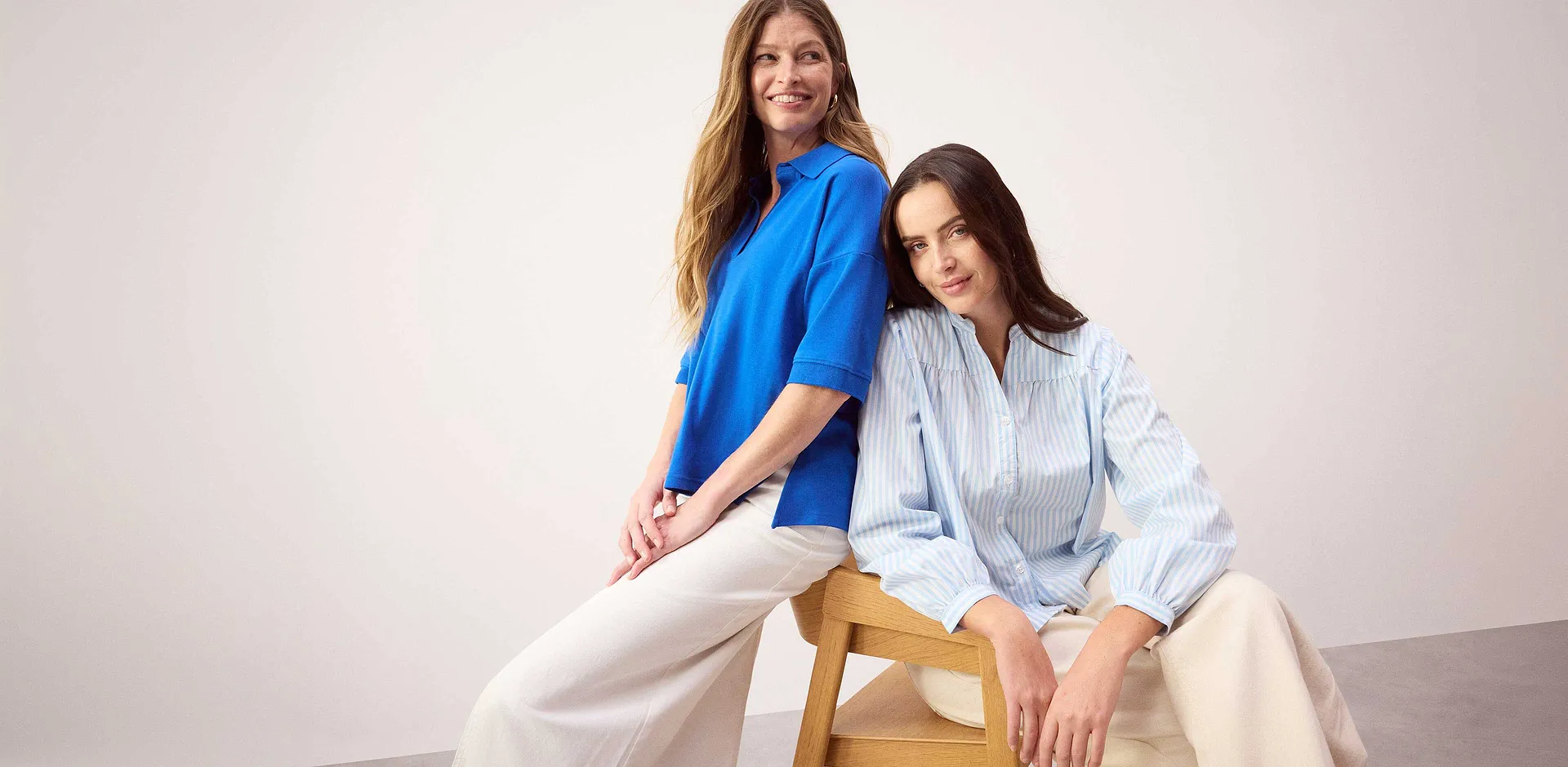 Polo bleu et chemisier ray&eacute; associ&eacute;s &agrave; un pantalon de couleur claire pour un style d&eacute;contract&eacute;. 