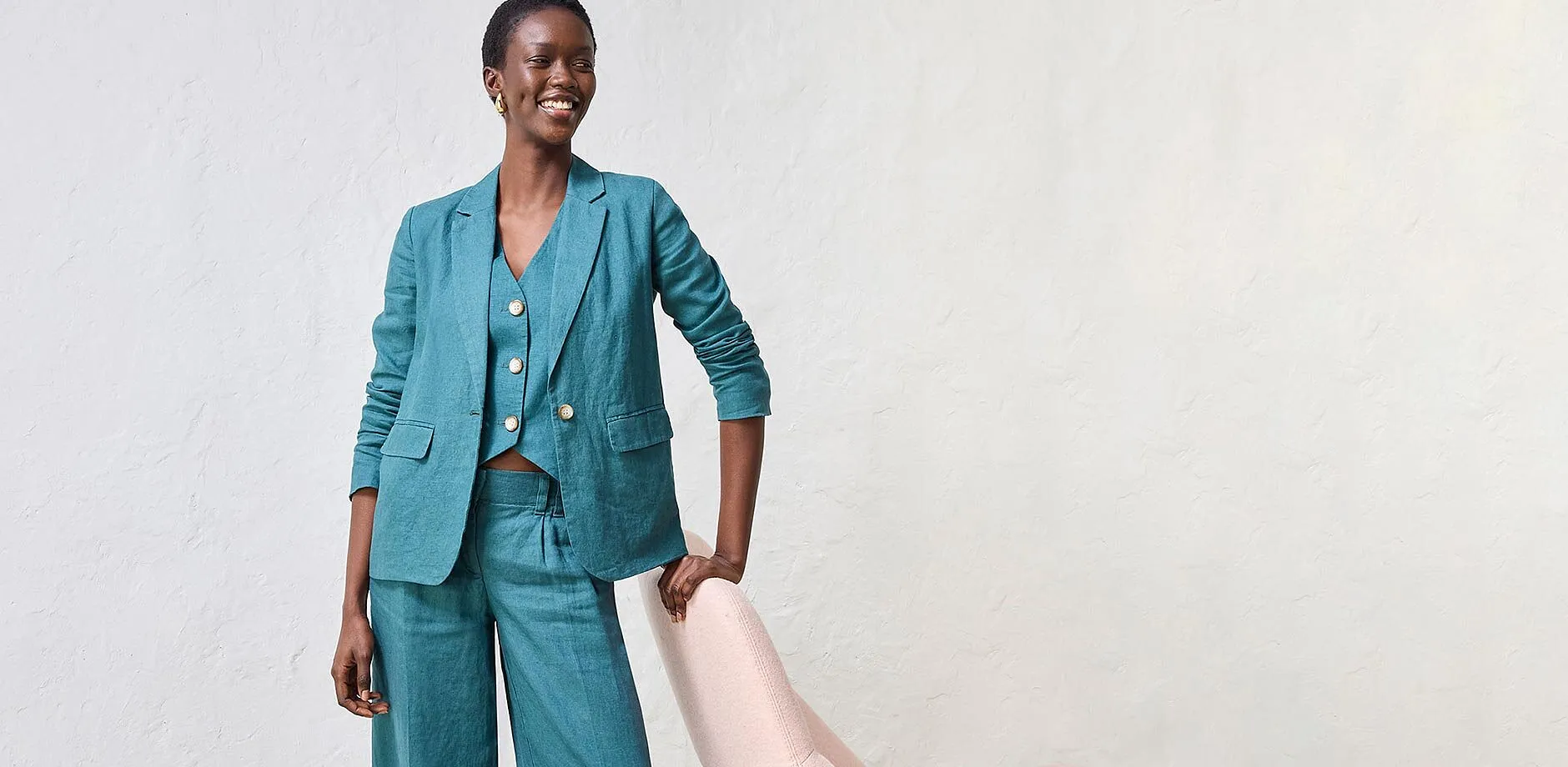 Ensemble tailleur pantalon turquoise avec pantalon large, gilet sans manches et veste.