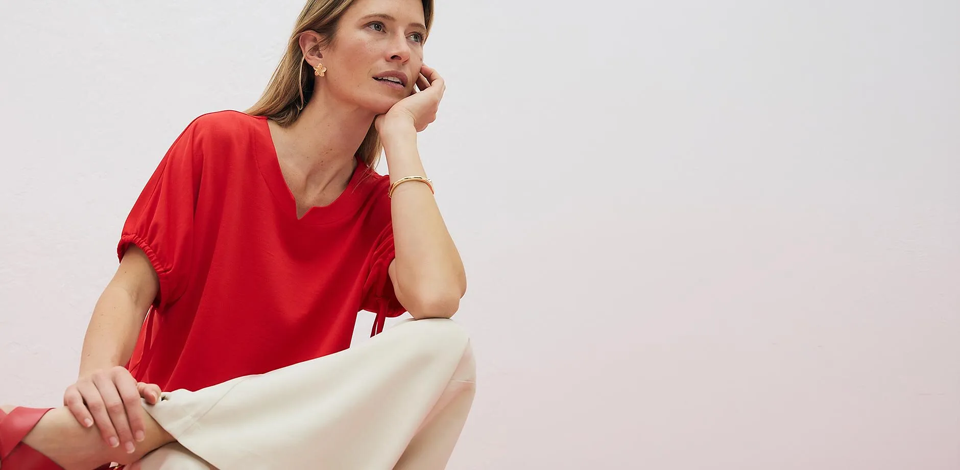 Haut rouge avec d&eacute;coupe en V au d&eacute;collet&eacute; et manches courtes.