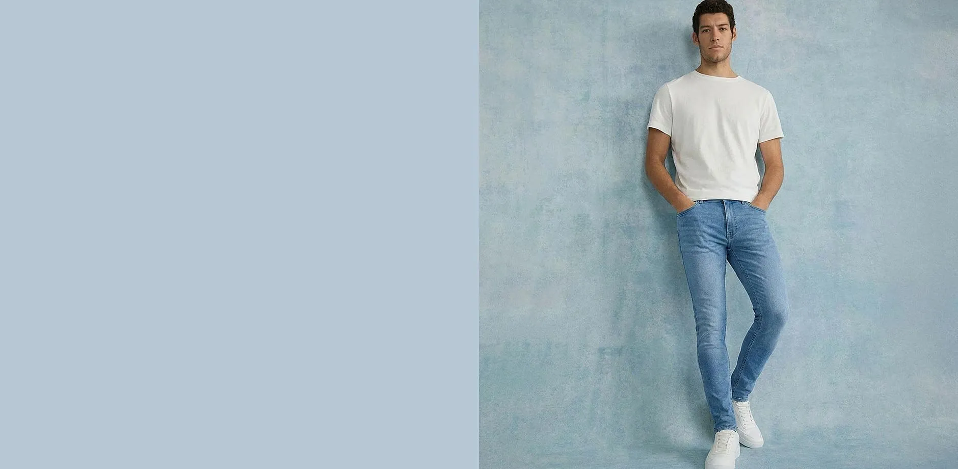 T-shirt blanc, jean bleu Slim Fit et sneakers blanches.