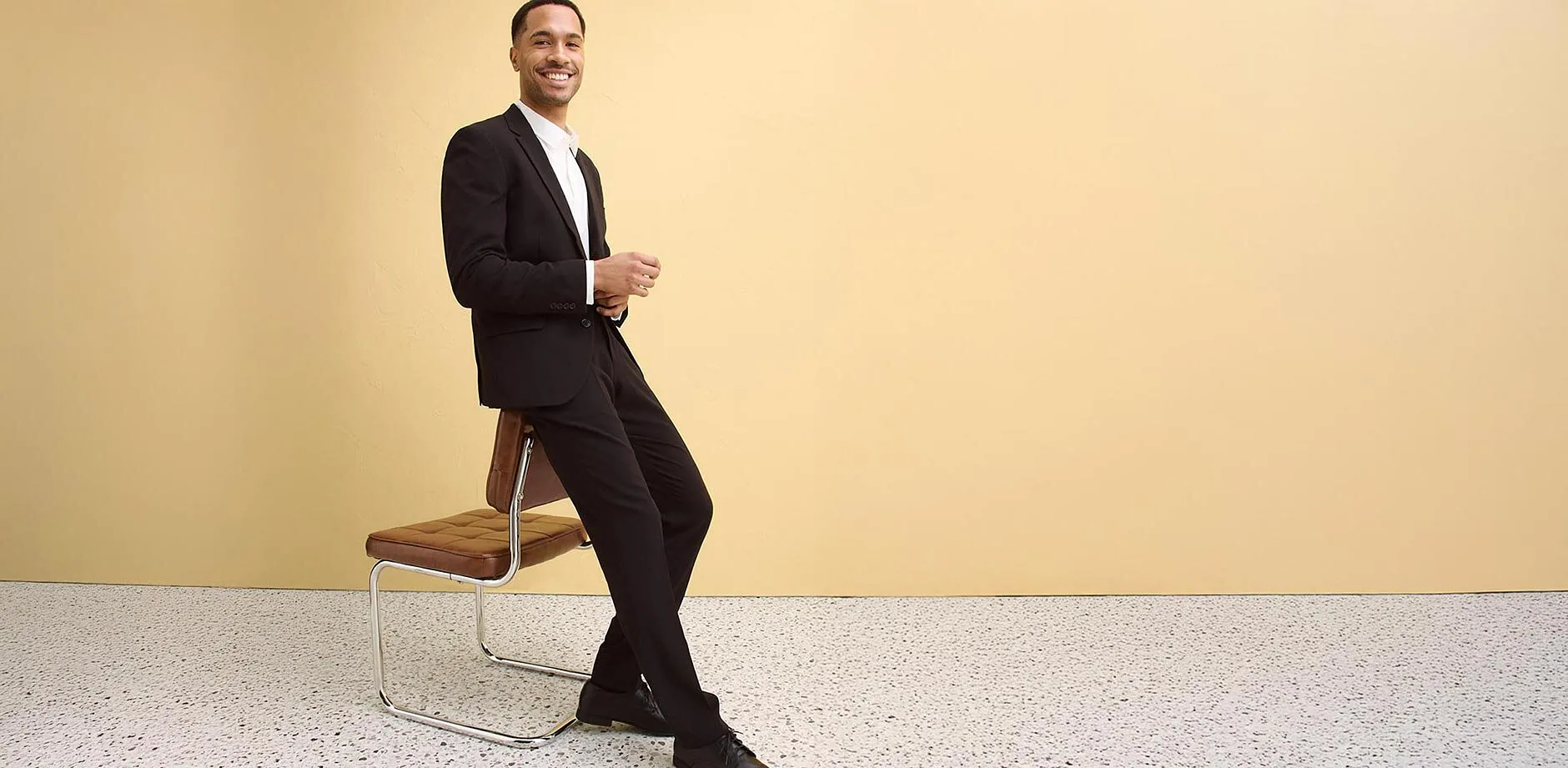 Costume noir &eacute;l&eacute;gant avec chemise blanche, chaussures assorties.