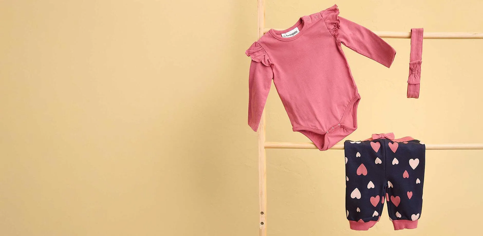 Adorable ensemble pour b&eacute;b&eacute; : body rose et pantalon bleu fonc&eacute; avec motifs c&oelig;urs.