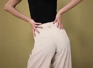Contraste élégant : haut sans manches noir associé à un pantalon large couleur crème à taille haute.