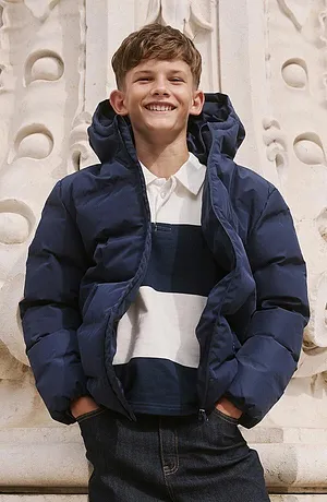 Veste d'hiver bleu foncé par dessus un pull rayé.