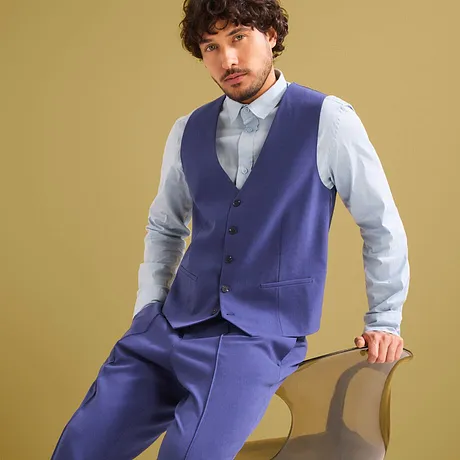 Costume bleu élégant avec gilet sans manches et chemise bleu clair.