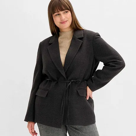 Blazer gris avec ceinture, associé à un pull à col roulé beige.