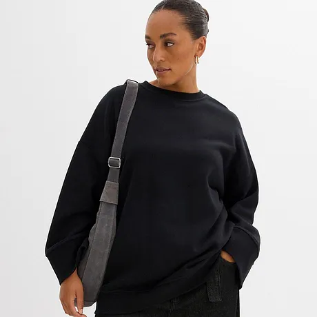 Sweat-shirt noir à col rond et sac à bandoulière gris.