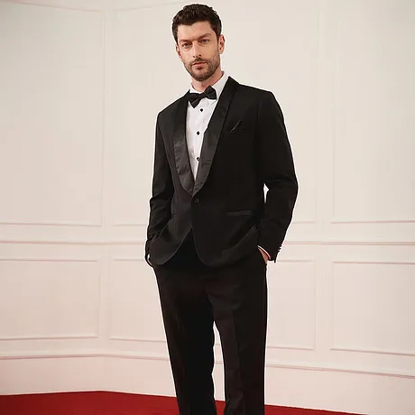 Smoking noir élégant avec nœud papillon et chemise blanche pour les fêtes.