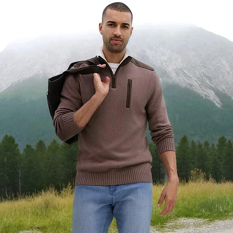 Un pull marron à col zippé associé à un jean clair.