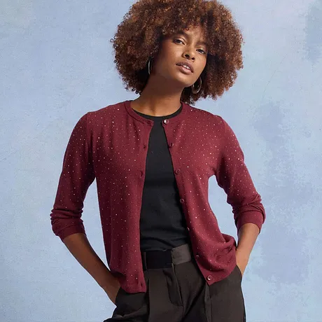 Gilet en maille rouge avec décorations brillantes, associé à un haut noir.