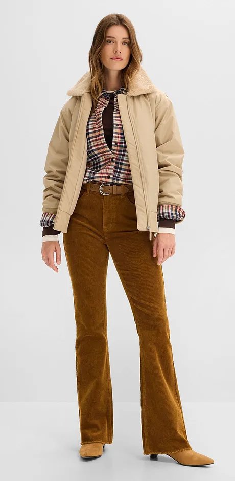 Veste beige, chemisier à carreaux et pantalon marron.