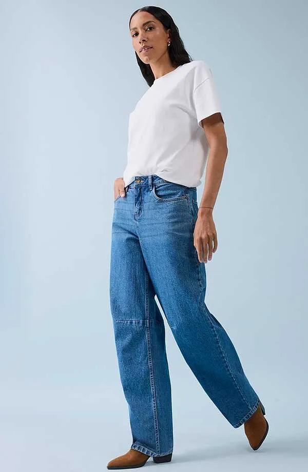 T-shirt blanc classique associé à un jean large et des chaussures marron.