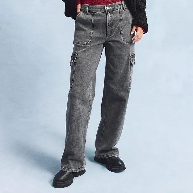 Jean cargo gris avec grandes poches latérales, associé à des chaussures noires.