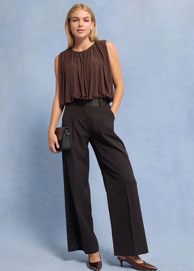 Top sans manches marron et pantalon large de couleur fonc&eacute;e.