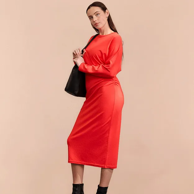 Robe midi rouge &eacute;l&eacute;gante &agrave; manches longues, associ&eacute;e &agrave; des bottines et un sac &agrave; main noirs.