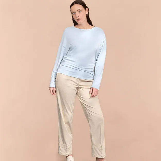 Pull bleu clair l&eacute;ger et pantalon beige.