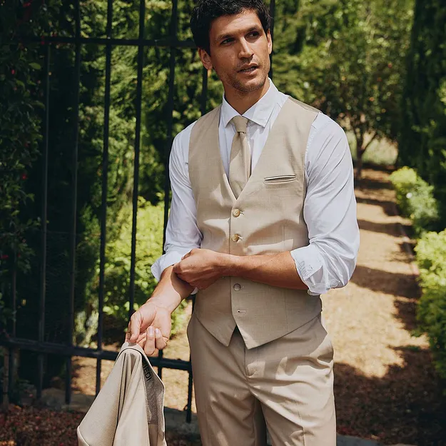 Gilet sans manches, pantalon et veste. Une chemise blanche et une cravate finalisent la tenue.