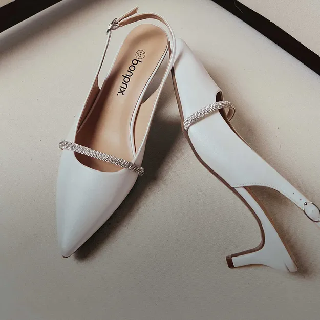 Escarpins blancs &eacute;l&eacute;gants avec petite bride et bout pointu. Des chaussures chics pour les grandes occasions.