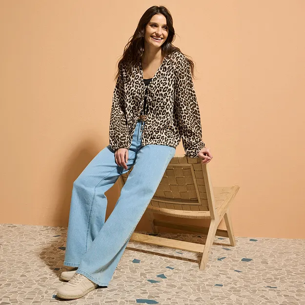 Blouse &agrave; imprim&eacute; l&eacute;opard associ&eacute;e &agrave; un jean &eacute;vas&eacute; bleu clair.