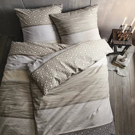 Parure de lit dans des teintes neutres avec des motifs g&eacute;om&eacute;triques.