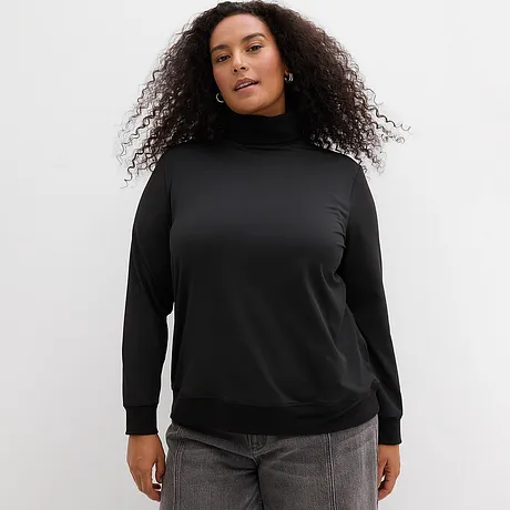 T-shirt noir à col roulé avec jean gris.