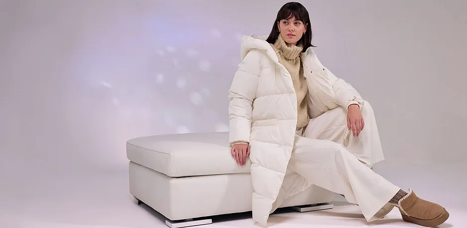 Manteau doudoune couleur crème, pantalon blanc et bottines chaudes.