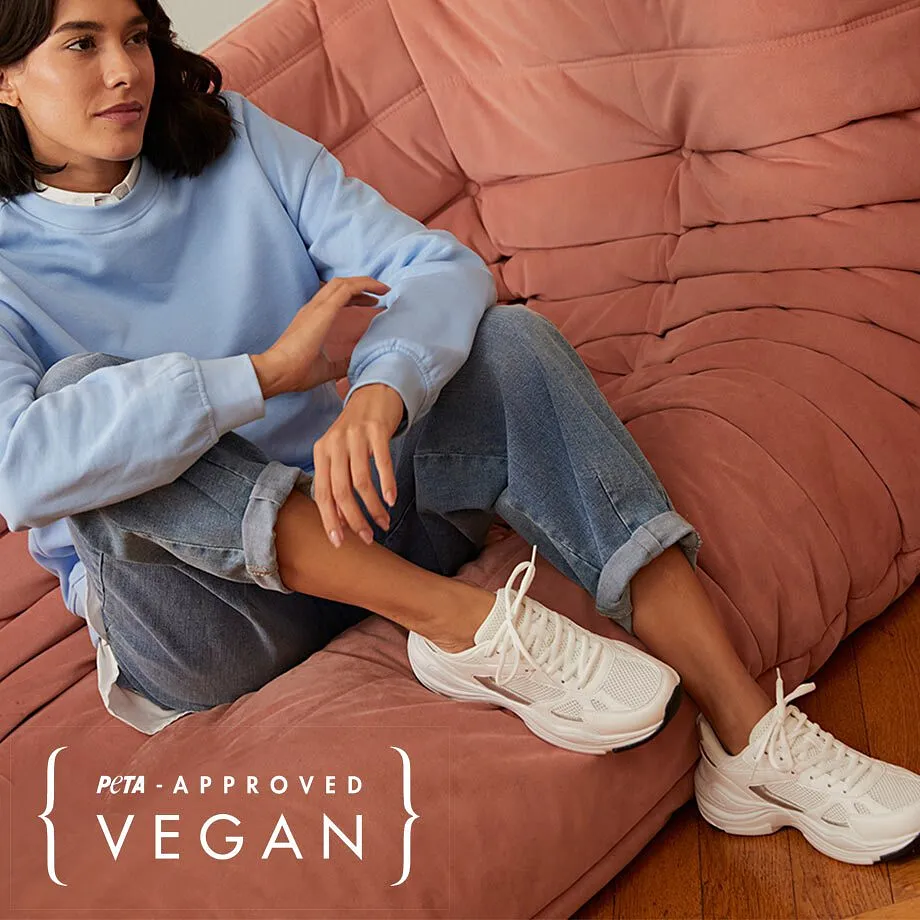 Pull bleu clair, jean confortable et sneakers blanches : une tenue décontractée pour des journées détente à la maison.