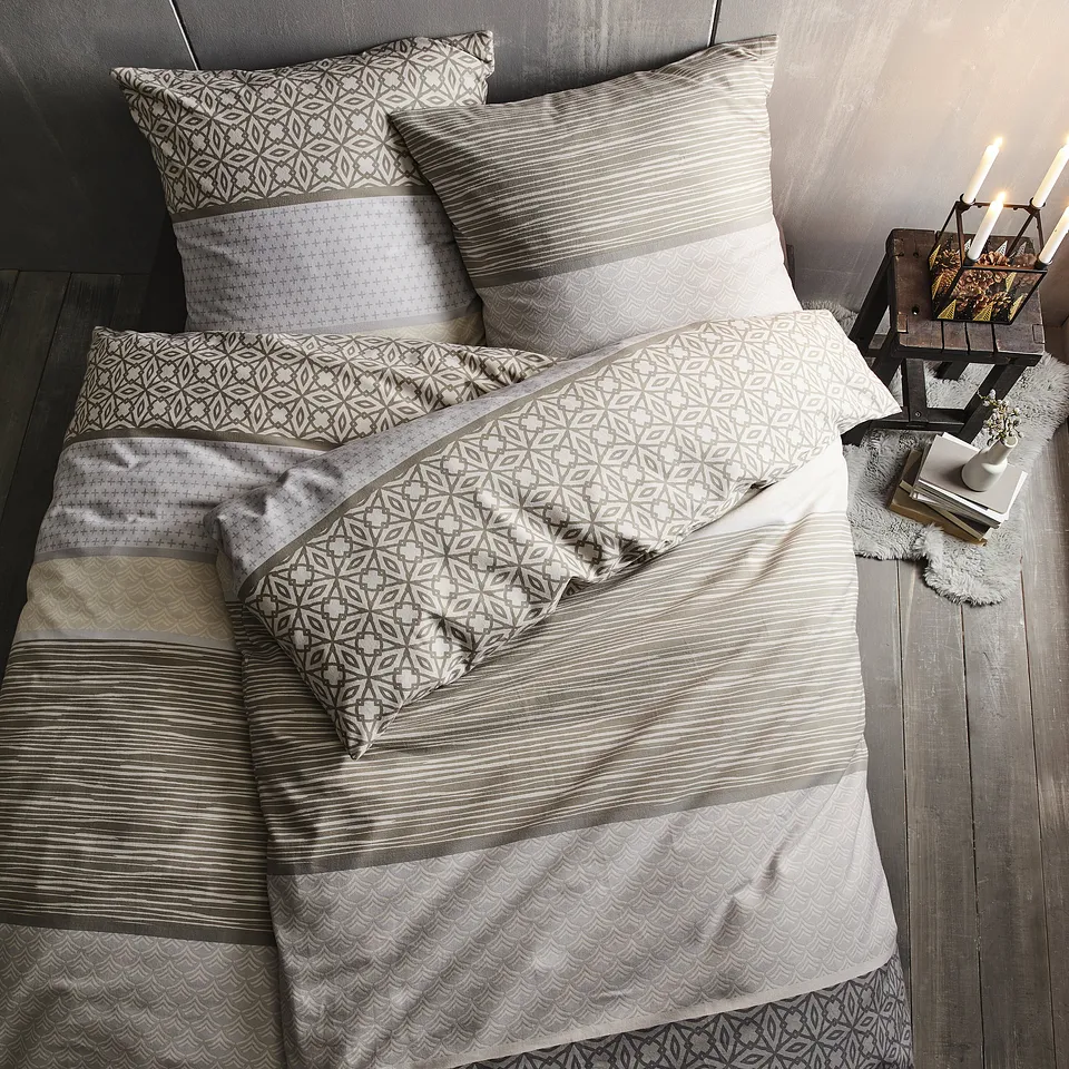 Parure de lit dans des teintes neutres avec des motifs géométriques.