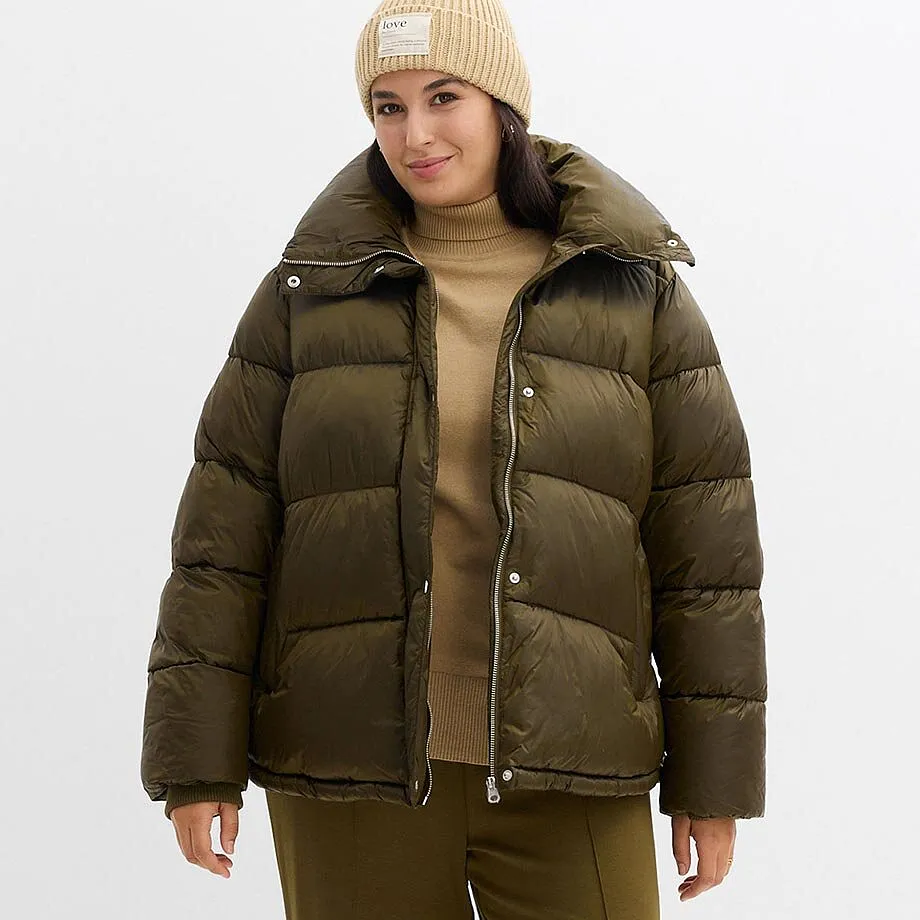 Doudoune chaude en vert olive, complétée d'un bonnet beige et d'un pull clair.