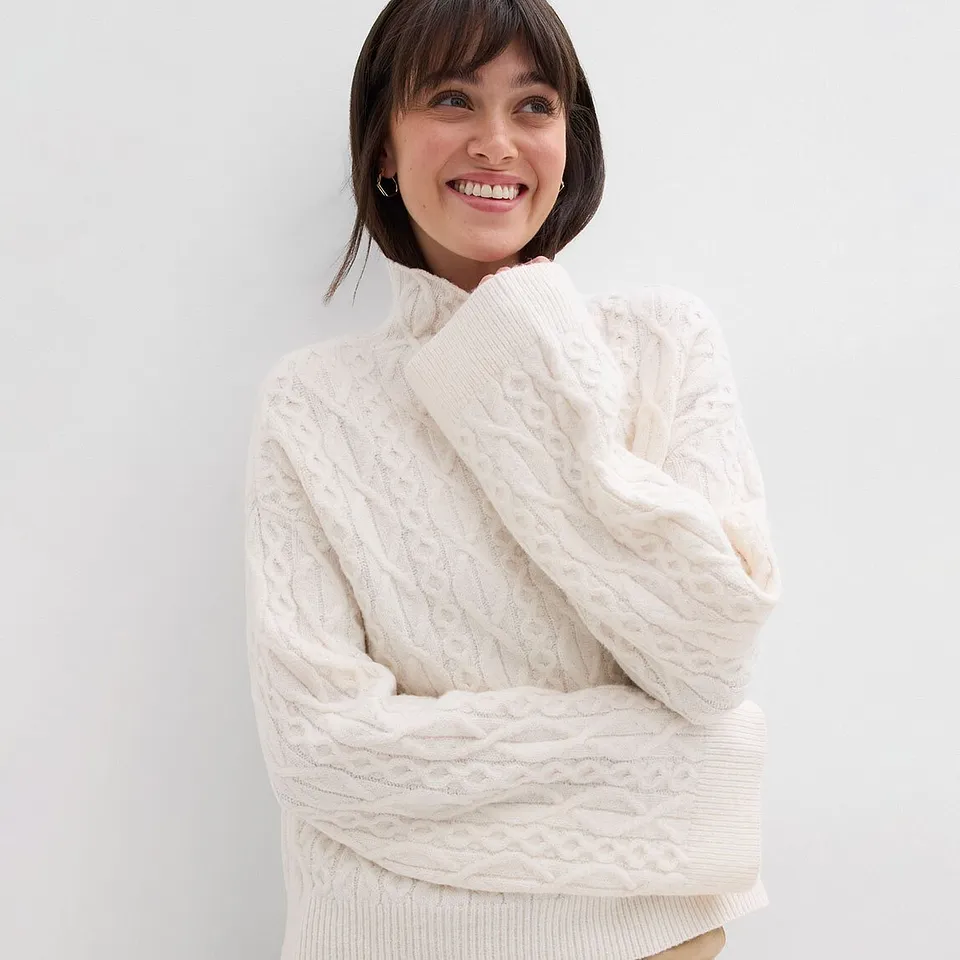 Pull en maille blanc à col montant et motif structuré.