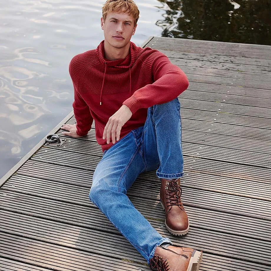 Pull rouge &agrave; capuche et jean bleu avec bottines marron.