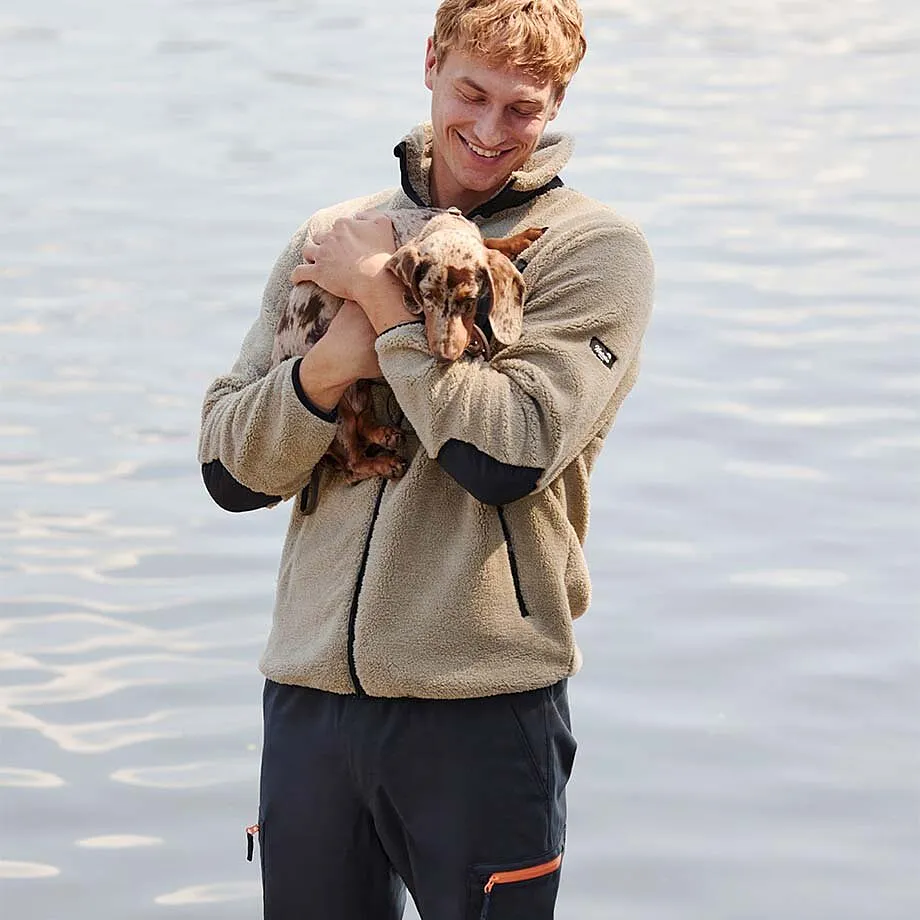 Veste en polaire beige, associ&eacute;e &agrave; un pantalon fonc&eacute;.