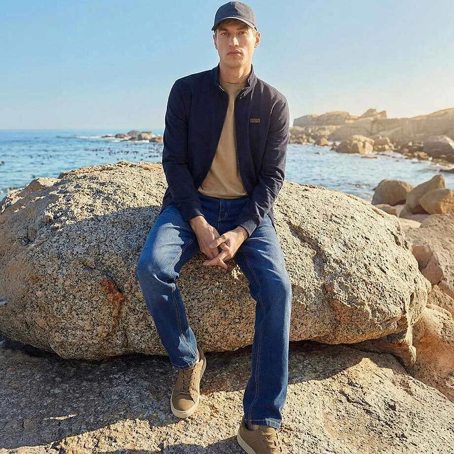 Veste bleue, T-shirt beige et jean pour une journ&eacute;e ensoleill&eacute;e &agrave; la mer.