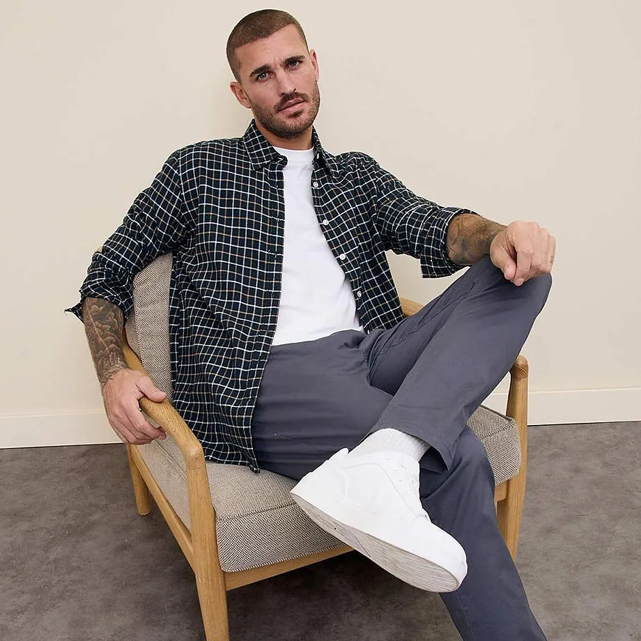 Chemise &agrave; carreaux sur un T-shirt blanc, pantalon gris et sneakers blanches. Un look mode et d&eacute;contract&eacute;.