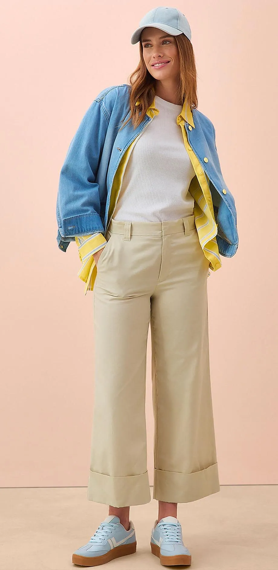 Tenue printani&egrave;re compos&eacute;e d'une veste en jean, un T-shirt blanc, une jupe-culotte beige et des sneakers bleu clair.