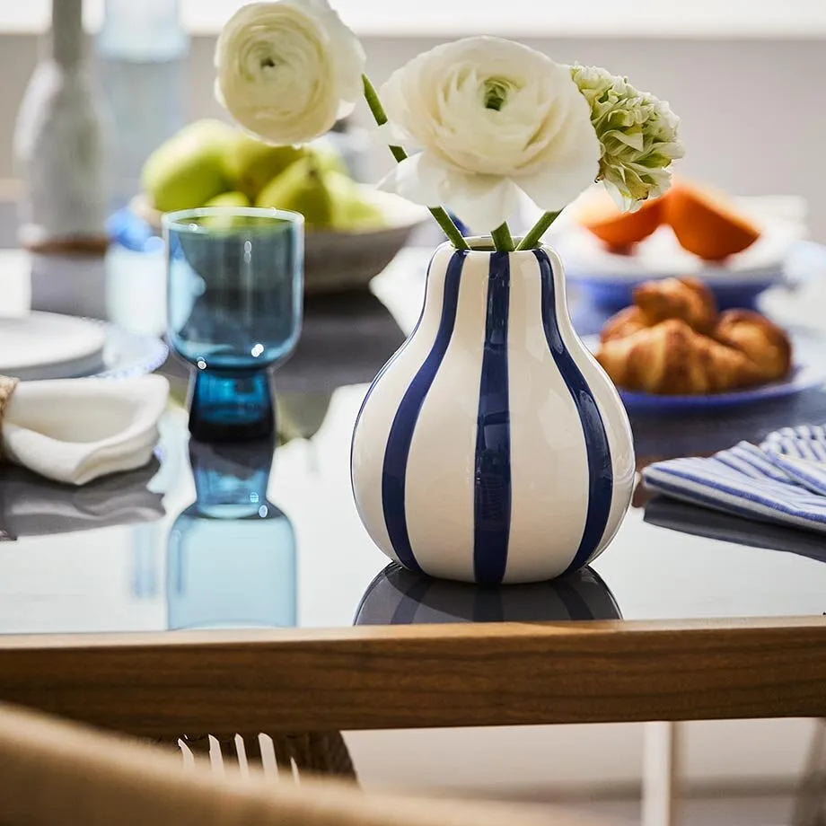 Un vase ray&eacute; avec fleurs blanches.