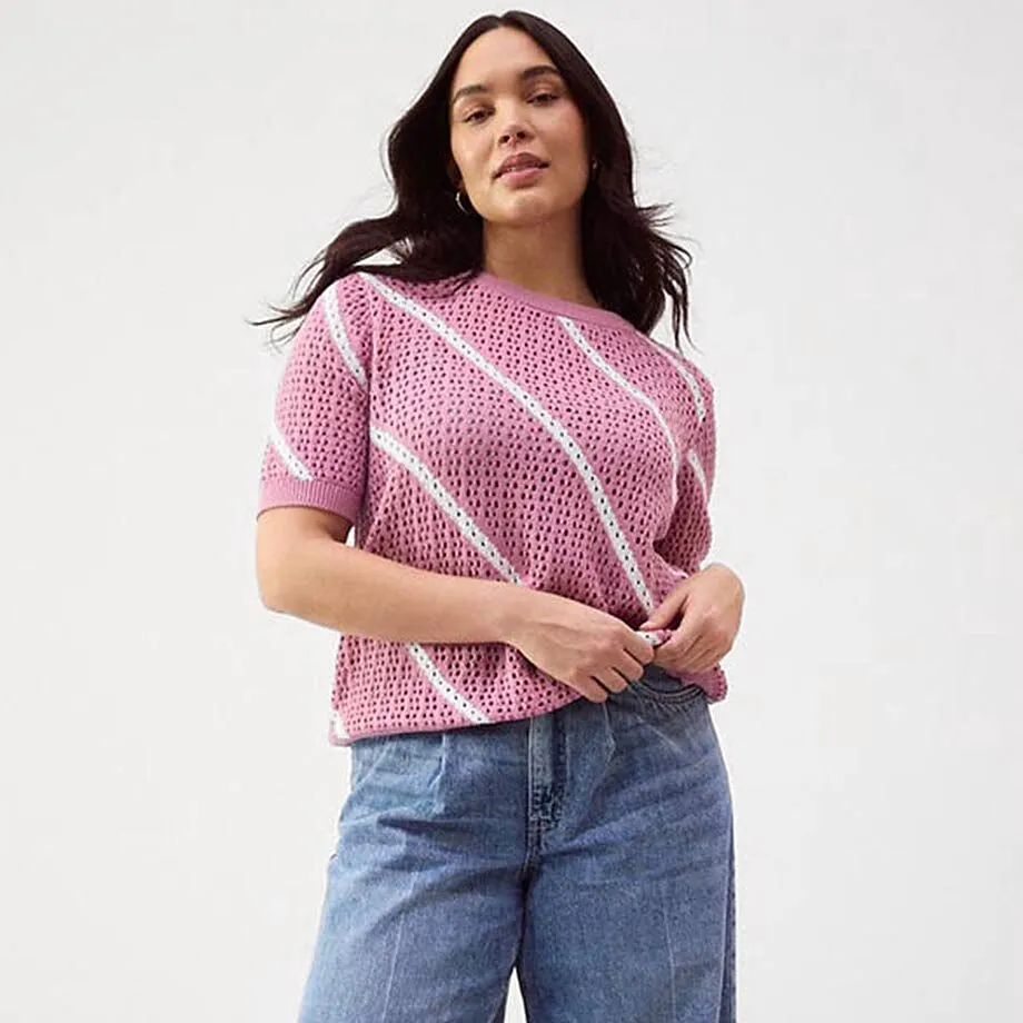 Pull en maille ample de couleur rose, associ&eacute; &agrave; un jean de coupe large.