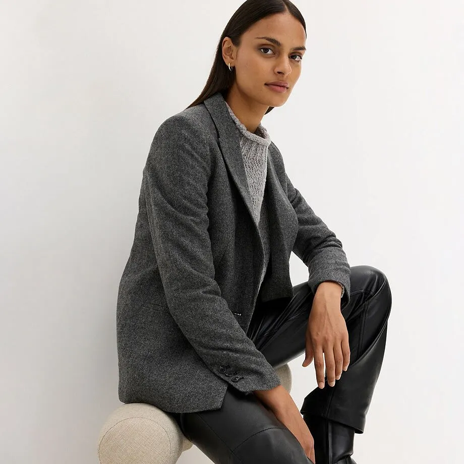 Blazer gris &eacute;l&eacute;gant associ&eacute; &agrave; un pantalon fonc&eacute;.