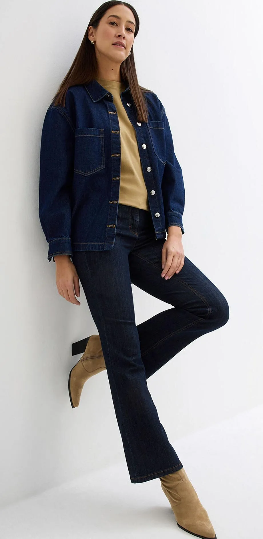 Veste en jean et jean bleu fonc&eacute;, pull beige et bottines &agrave; bout pointu.