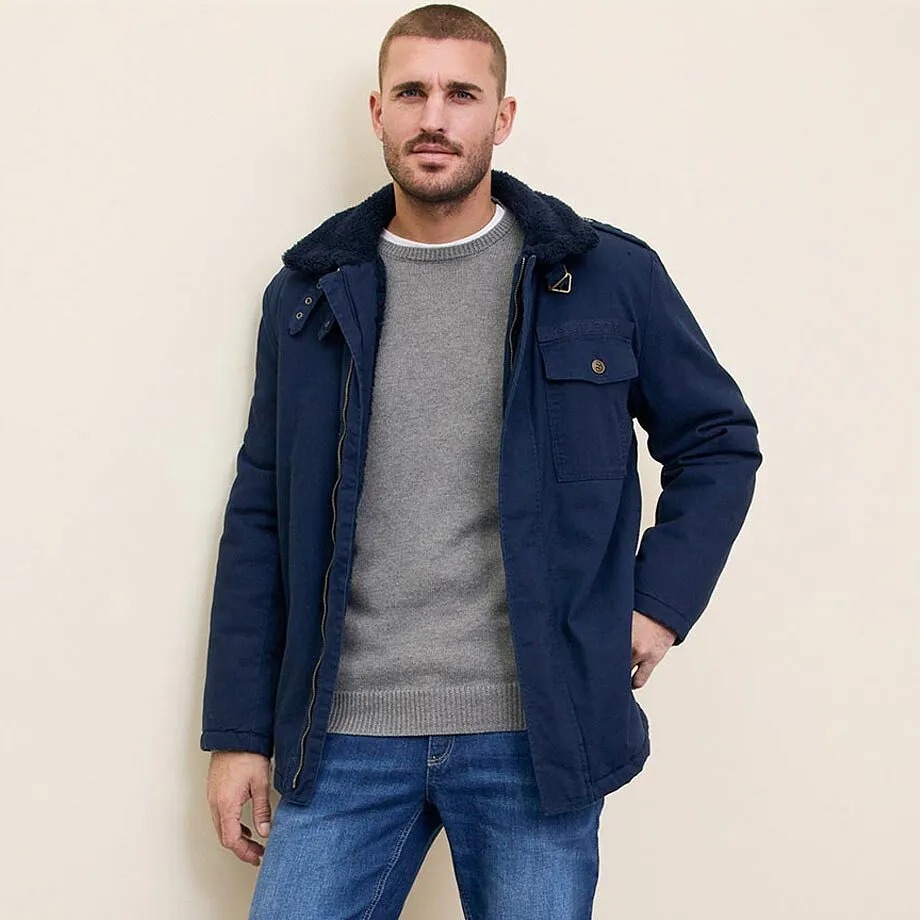 Veste bleue, pull gris et jean.