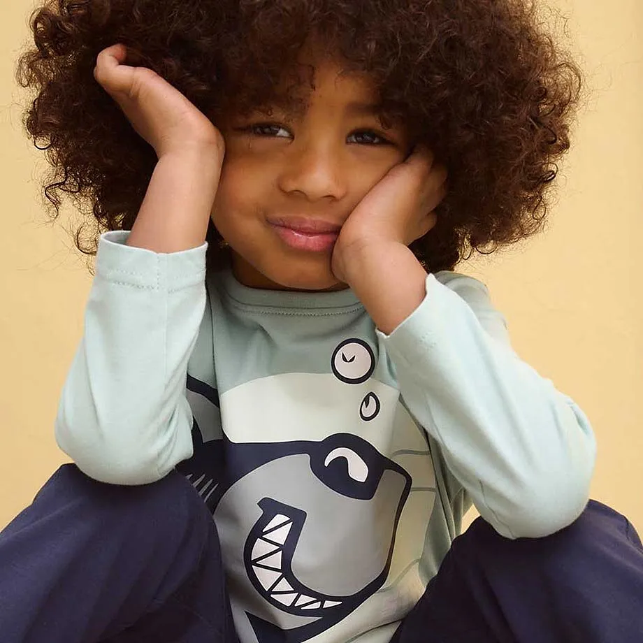 Pull avec motif requin, associ&eacute; &agrave; un pantalon fonc&eacute;.